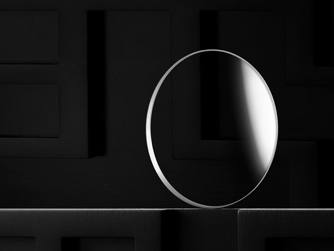 Tissot sapphire watch crystal photographed against a dark background